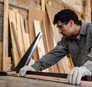 Man sawing board in loud space