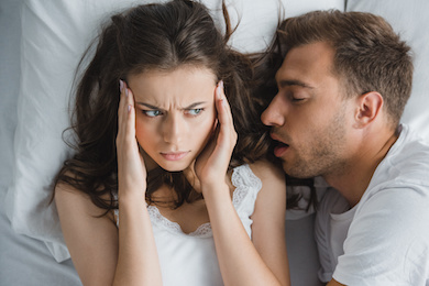 Man snoring into woman's ear
